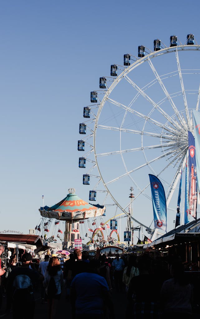 A bustling day at Stuttgart fairground featuring a towering Ferris wheel and carnival rides.